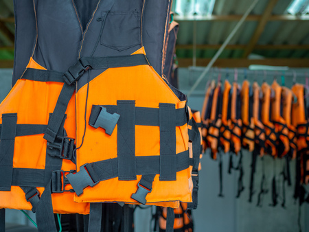 Life jackets safety equipment hanging on the bars for the tourism service.の写真素材