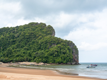 Seascape. Motor boat and wooden local travel passenger ferry boat floating on the sea near the beach and rock mountain on blue sky background in Thailand.の写真素材