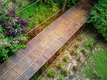 Wooden bridge walkway. Bamboo Bridge with tree and flower park and paddy top view.の写真素材