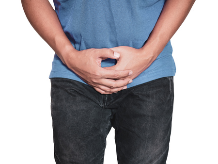 Man hands holding on middle crotch of trousers with pain action isolated on white background.の写真素材