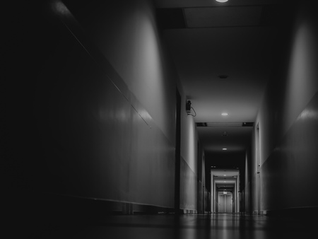 Dark mysterious corridor in building. Door room perspective in lonely quiet building with light on black and white style. horror landscape concept.の写真素材