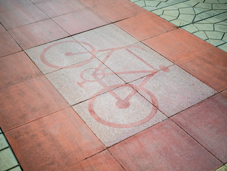 Bike lane sign on red floor. Bicycle symbol on red footpath.