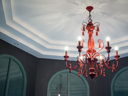 Classic vintage crystal chandelier lamp on the white ceiling with green vintage wooden window on black wall in contemporary house with copy space.の写真素材