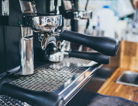Portafilter on coffee machine on wooden table in cafe.の写真素材