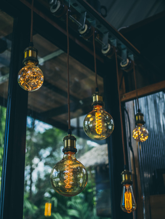 Decorative antique edison vintage style light bulbs on cafe background vertical style.