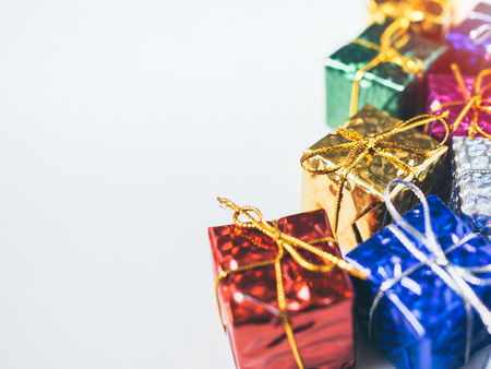 Close-up small colorful gift boxes on white background with copy space. Top view of many gifts...