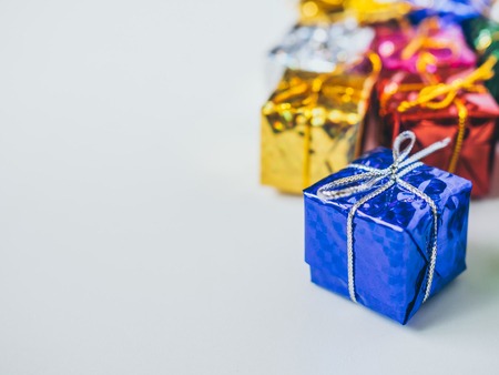 Small colorful gift boxes on white background with copy space. Top view of many gifts wrapped colorful shiny paper.の写真素材