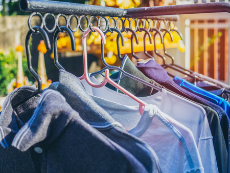 Many colors shirts on hanger are hanging on the clothesline with sunshine.の写真素材