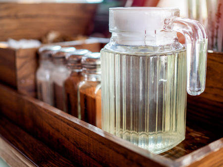 Syrup in the glass jug on wooden shelf in coffee shop.