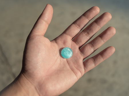 Blue cough drops in hand. Lozenge sore throat.の写真素材