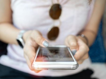 Close-up woman's hand using smartphone. Human with technology concept.