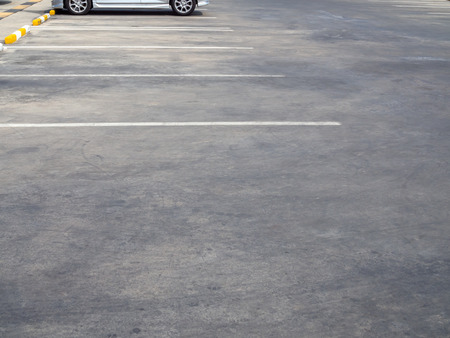 Empty old outdoor parking lot with car and white line on sunny day with copy space.の写真素材