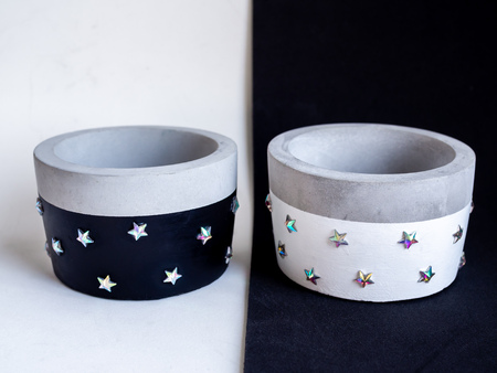 Empty black and white modern round concrete planters with shining star pattern on black and white background. Painted concrete pots for home decorationの写真素材