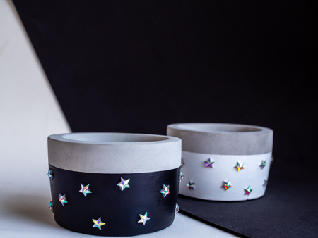 Empty black and white modern round concrete planters with shining star pattern on black and white background with copy space. Painted concrete pots for home decorationの写真素材