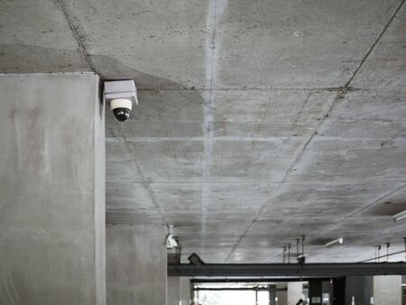 CCTV camera installed on concrete ceiling in the parking lot with copy space.の写真素材