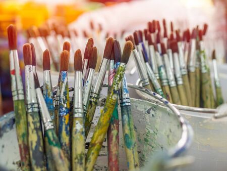 Artist paint brushes. Many artist tools in plastic bucket, art equipment.の写真素材
