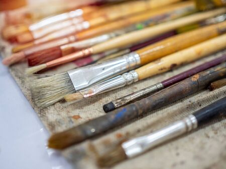 Artist paint brush set. Close-up many artist tools in calico paint brush holder, art equipment.の写真素材