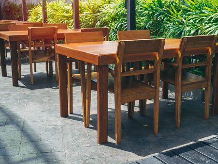 Empty wooden dining table set near the green garden.の写真素材