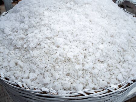 Close-up white sea salt in white basket. Salt farming, salt process production concept.