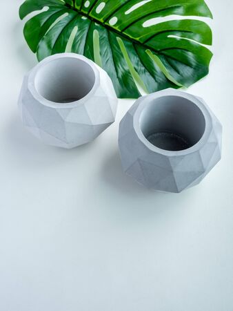 Concrete pot. Top view of two empty modern geometric concrete planters with green tropical palm leaf isolated on white background with copy space.の写真素材