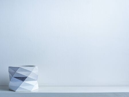 Cactus pot. Beautiful painted concrete pot. Empty modern geometric concrete planter, white painted on white wooden shelf on white wall background with copy space.の写真素材