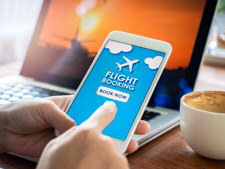 Flight booking online with smartphone. Finger touching on mobile phone for booking air flight online...
