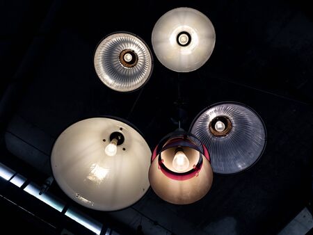Ceiling light retro style hanging from ceiling in dark room, view from the bottom.