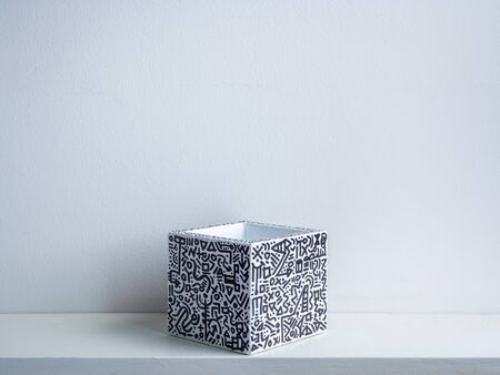 Cactus pot. Concrete pot. Empty white with modern graphic pattern geometric concrete planter on white wooden shelf isolated on white wall background.の写真素材