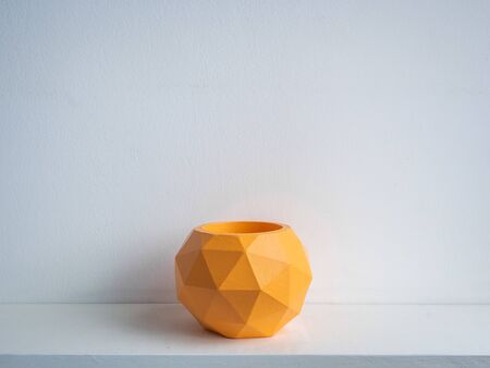 Cactus pot. Concrete pot. Empty orange modern geometric concrete planter on white wooden shelf isolated on white background.の写真素材