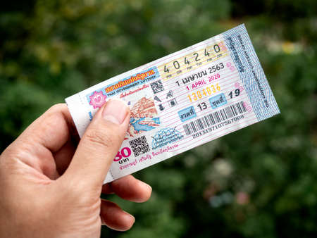 Bangkok, Thailand - April 14, 2020: Hand holding Thai Lottery for the period April 1, 2020. Thai national lottery scheduled for April 1 will now take place on May 2, and may be postponed because the effects of Covid-19 coronavirus pandemic.のeditorial素材