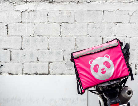 Bangkok, Thailand - April 18, 2020: Food Panda Delivery, Man with pink delivery container with motorcycle for food delivery by Food Panda, famous application on smartphone.のeditorial素材