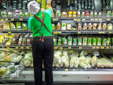 Bangkok, Thailand - April 14, 2020: Staff arranging the new fresh vegetables on the shelves in supermarket in bangkok, Thailand.のeditorial素材