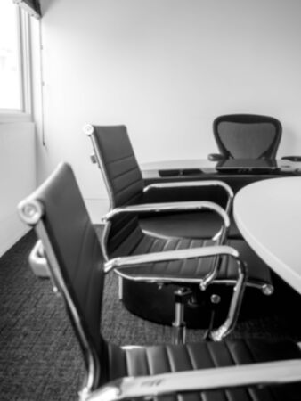 Blurred modern conference room background, decoration with three black luxury leather chairs near...