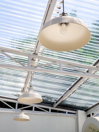 Modern ceiling lights hanging under the transparent roof, vertical style.の写真素材