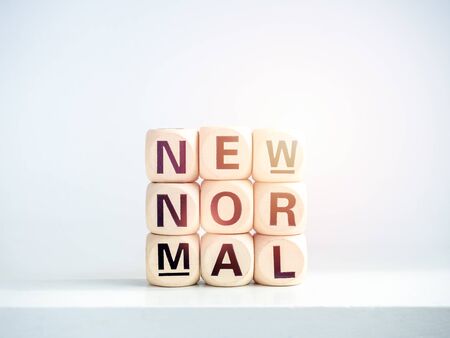 Close-up New Normal, words on wooden alphabet cube on shelf on white background. New normal after...
