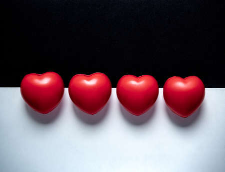 Four red hearts on black and white background with copy space. Many red ball foam with heart shape. Love, care, and apartheid Concept.の写真素材