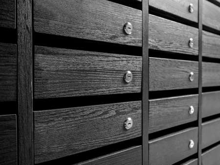 Close-up raws of wooden unnumbered mailboxes and lockers for resident in condominium or apartment....