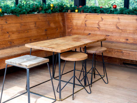 Empty wooden table and wooden chairs with Christmas ornament object decorations interior.の写真素材