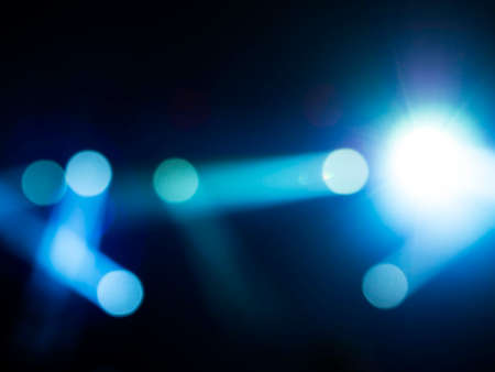 Blurred stage light concert background with blue color beam and laser rays on stage. Defocused...