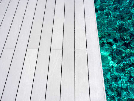 White clean wood plank floor on poolside. Blank space on wooden floor near swimming pool, summer...