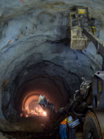 Blurred background of railway tunnel construction site vertical style. Blurry of excavator working...