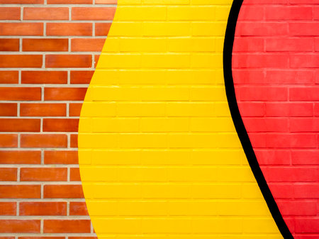 Brick wall background with yellow and red painted.Empty space on vivid color brick wall texture.の写真素材