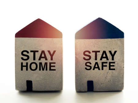 Stay safe concept. Words "Stay Home" and "Stay Safe" on small concrete house shape isolated on white background. Social media campaign for covid-19 or coronavirus pandemic prevention.の写真素材