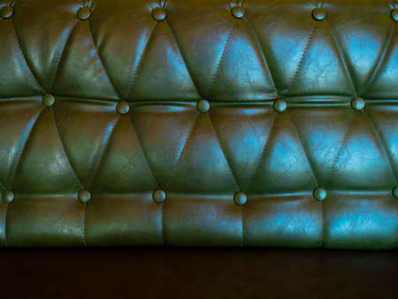 Leather sofa with pins and buttons background. Close up of vintage dark green long leather sofa seat texture background.の写真素材