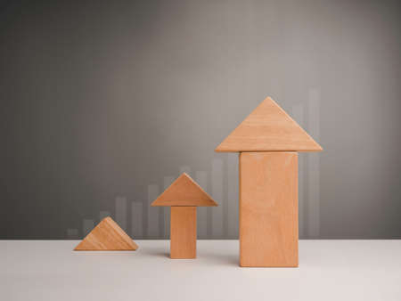 Business growth success concept. Three size of wooden blocks stacking as arrow up averages as a growth graph chart with copy space, minimal and eco style.の写真素材