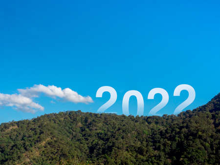 Happy New year 2022 with large letters on the lush green fertile mountains and blue sky, beautiful view with copy space, a successful concept. Welcome, Merry Christmas, and Happy New Year in 2022.の写真素材