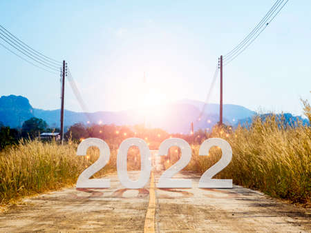 Happy New year 2022 with large letters on local open road head to the big mountain on sunrise to...