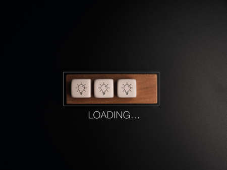 Loading..., the word with light bulb icon on white dices and wood cube block in the progress bar on...