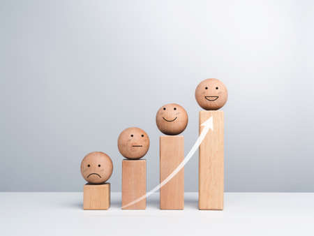 Satisfaction and business growth process and economic improvement concept. Emoticon, emotion faces wooden balls and wood cube blocks chart steps on white background with copy space, minimal style.の写真素材