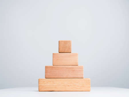 Blank business chart steps made by stack of wooden cube blocks in pyramid shape isolated on white background, eco friendly and minimal style.の写真素材